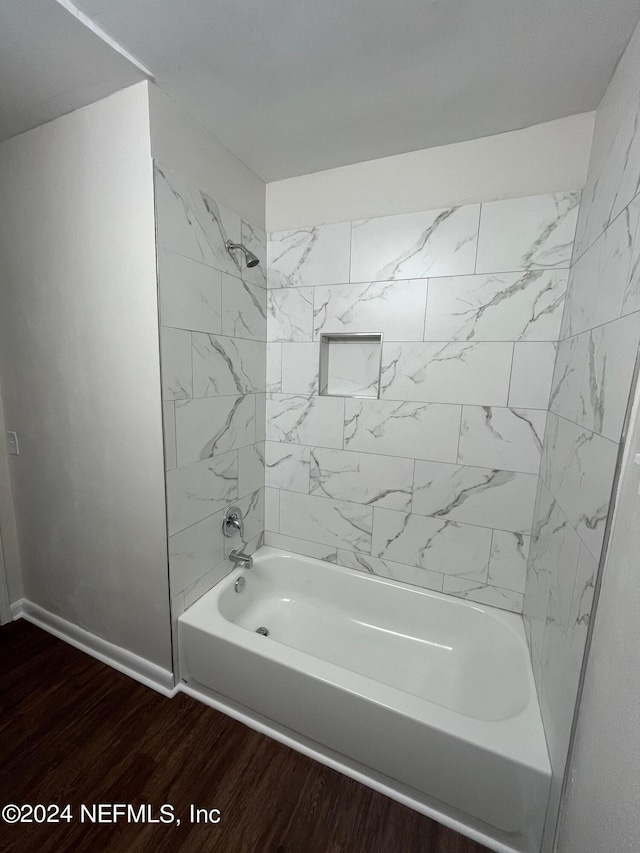 bathroom with wood-type flooring and tiled shower / bath