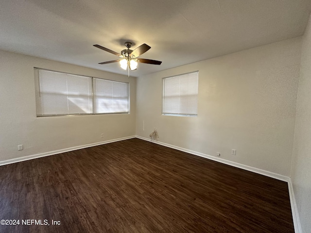 unfurnished room with ceiling fan and dark hardwood / wood-style flooring