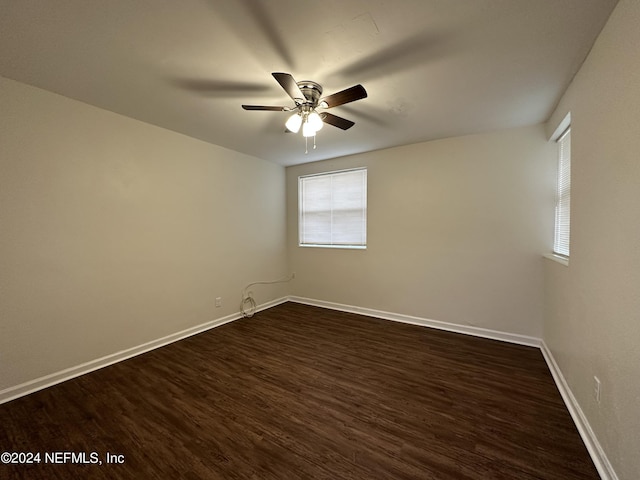 spare room featuring ceiling fan and dark wood-type flooring