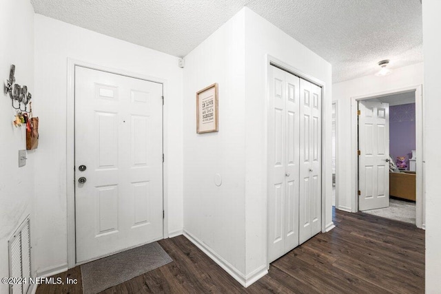 entrance foyer featuring dark hardwood / wood-style flooring and a textured ceiling