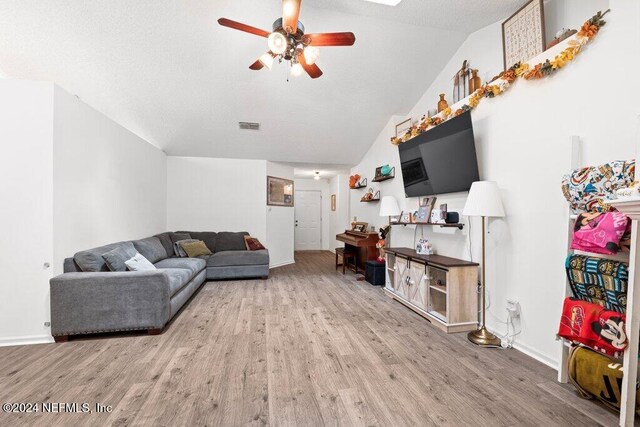 living room with ceiling fan, hardwood / wood-style floors, and lofted ceiling