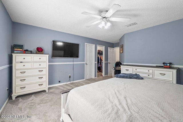 carpeted bedroom featuring a textured ceiling and ceiling fan