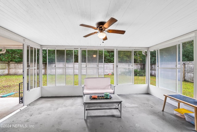 unfurnished sunroom featuring wood ceiling, plenty of natural light, and ceiling fan