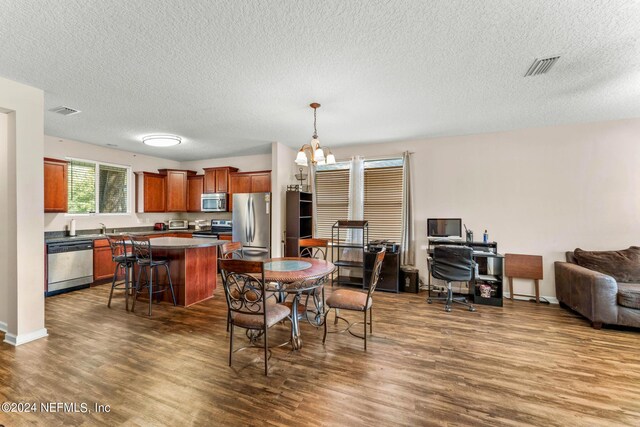 dining area featuring sink, dark hardwood / wood-style flooring, a textured ceiling, and a chandelier