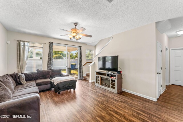 living room featuring a textured ceiling, ceiling fan, and dark hardwood / wood-style flooring