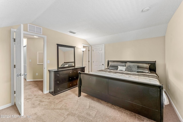 bedroom with light carpet, a textured ceiling, and vaulted ceiling