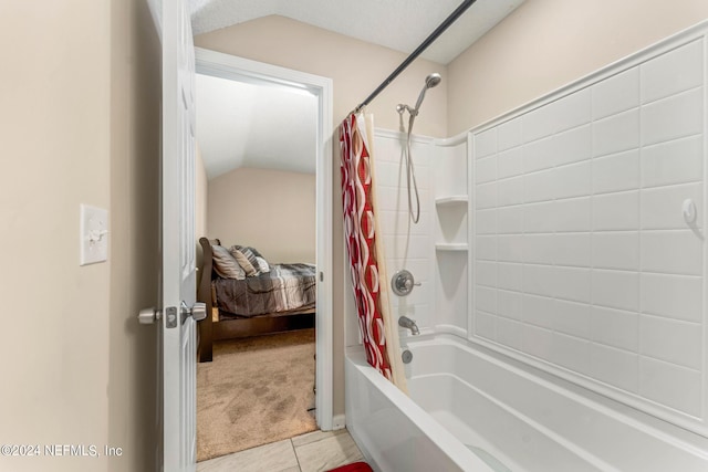 bathroom with lofted ceiling, a textured ceiling, and shower / tub combo with curtain