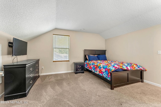 bedroom with lofted ceiling, a textured ceiling, baseboards, and carpet flooring