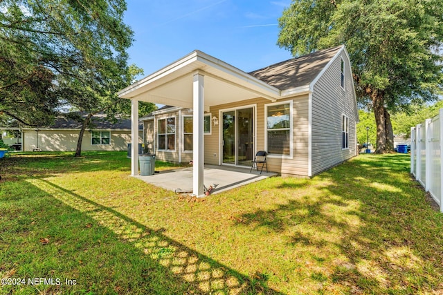 back of property with a yard, fence, and a patio