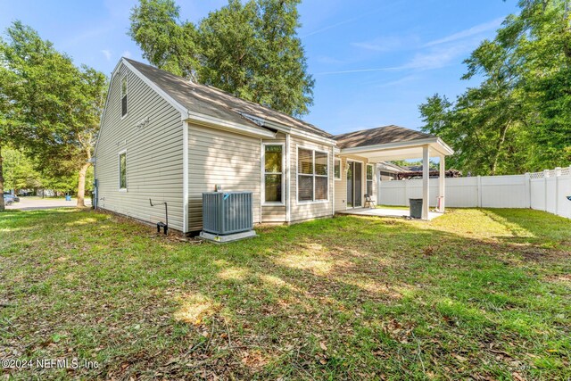 back of house with a yard, central AC unit, and a patio area