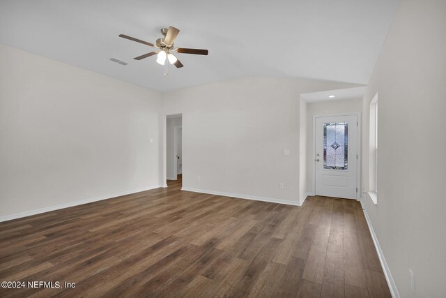 empty room featuring ceiling fan, dark hardwood / wood-style flooring, and vaulted ceiling