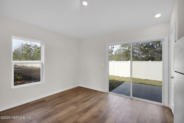 empty room featuring hardwood / wood-style flooring and a healthy amount of sunlight