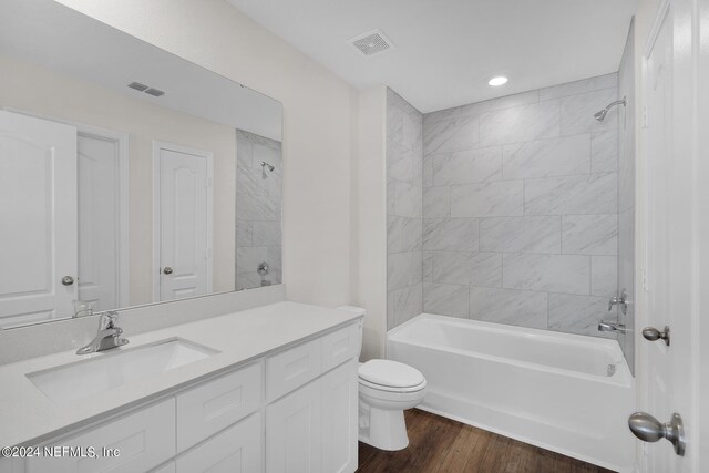 full bathroom with wood-type flooring, vanity, toilet, and tiled shower / bath