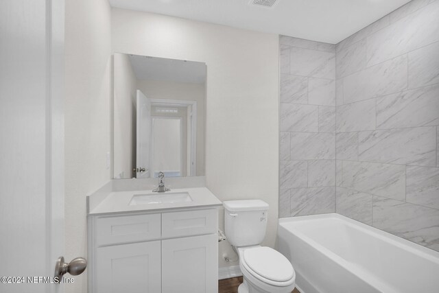 full bathroom with vanity, toilet, and tiled shower / bath combo