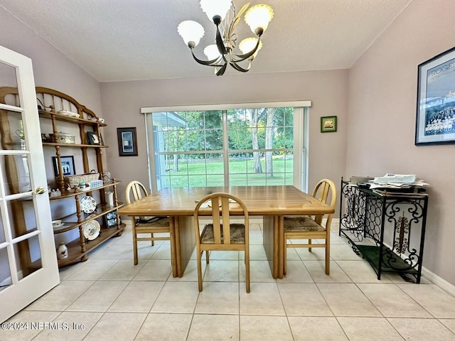 tiled dining area featuring a textured ceiling and a notable chandelier