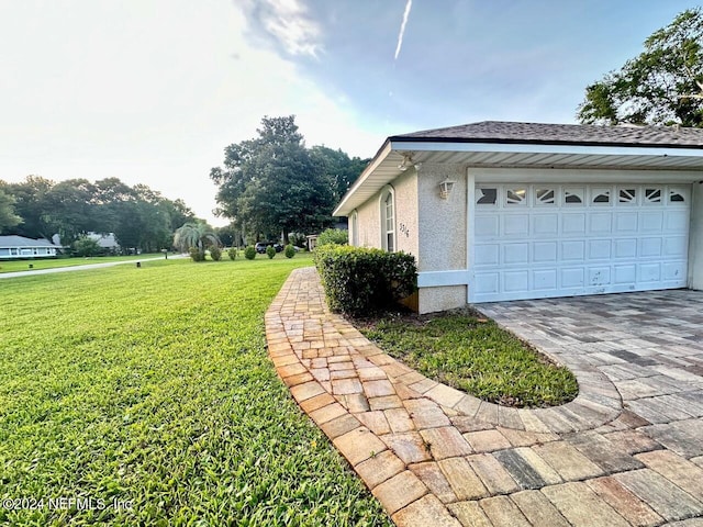 view of home's exterior featuring a garage and a yard