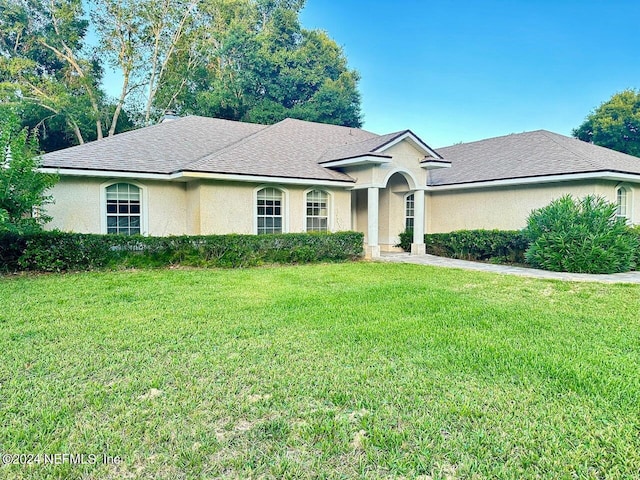 single story home featuring a front lawn