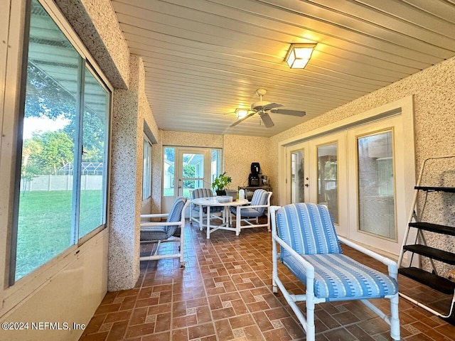 sunroom featuring ceiling fan and wood ceiling