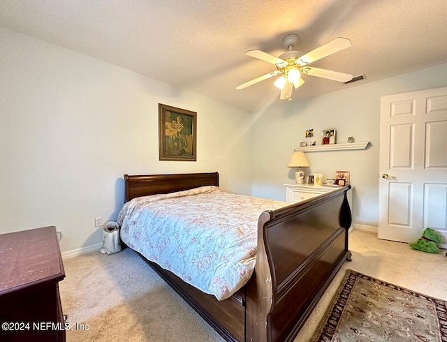 bedroom with carpet, ceiling fan, and a textured ceiling