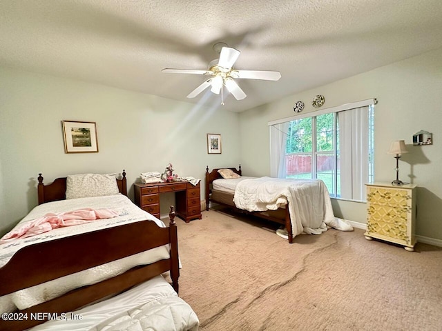 carpeted bedroom with ceiling fan and a textured ceiling