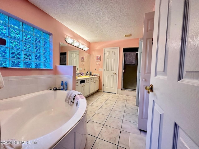 bathroom featuring separate shower and tub, tile patterned flooring, vanity, and a textured ceiling