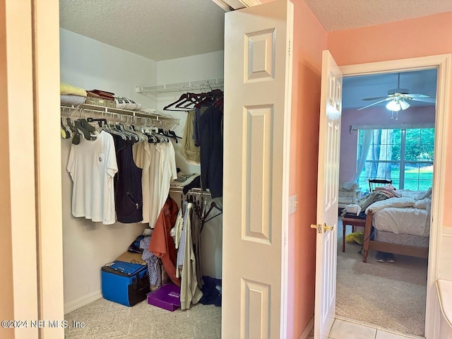 spacious closet with light colored carpet and ceiling fan