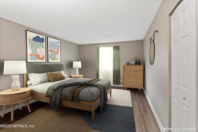 bedroom with dark wood-type flooring and a closet