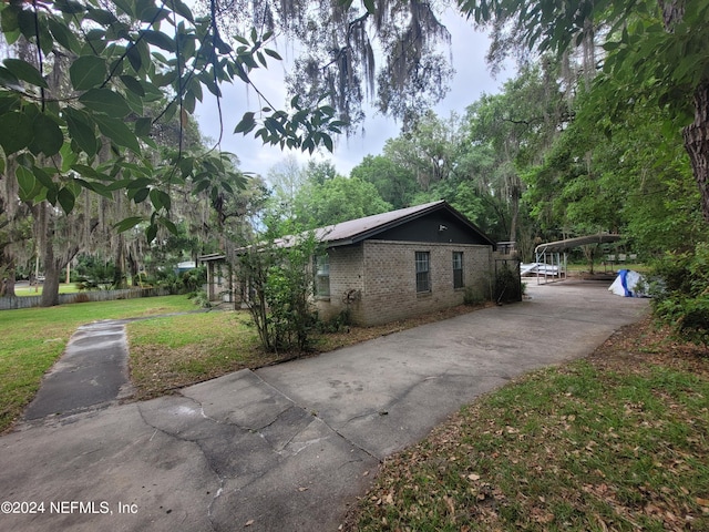 view of home's exterior featuring a carport and a lawn