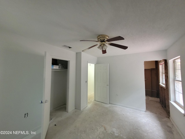 unfurnished bedroom featuring ceiling fan and a closet