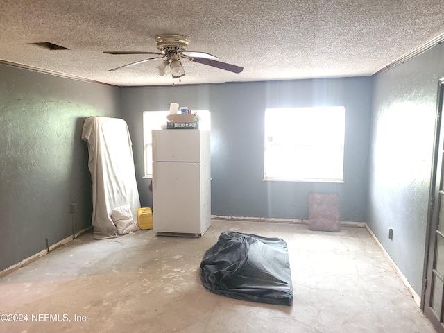 spare room featuring ceiling fan, a textured ceiling, and concrete floors