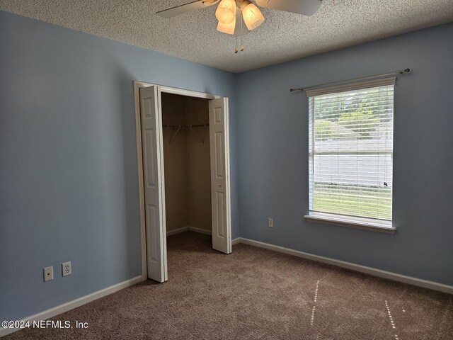 unfurnished bedroom with carpet, ceiling fan, a closet, and a textured ceiling