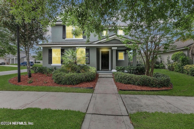 traditional home with a front yard and stucco siding