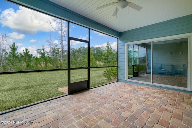 unfurnished sunroom featuring ceiling fan