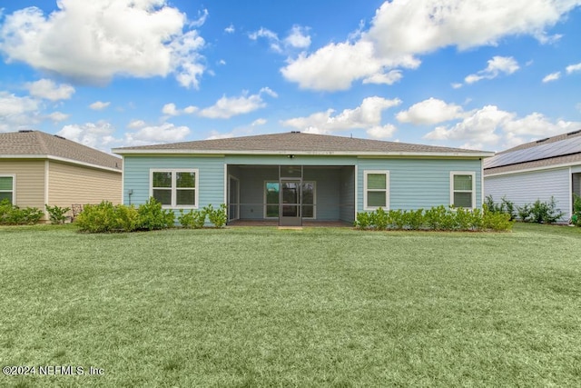 back of house with a lawn and a sunroom