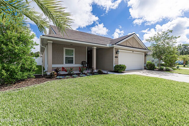 single story home featuring a front lawn, covered porch, and a garage