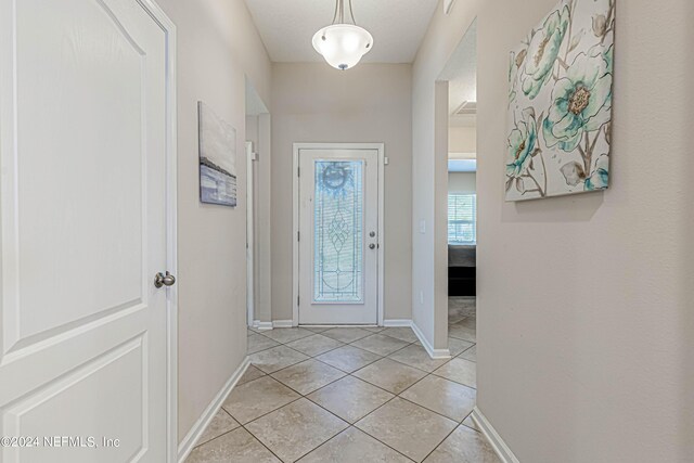 doorway to outside featuring light tile patterned flooring