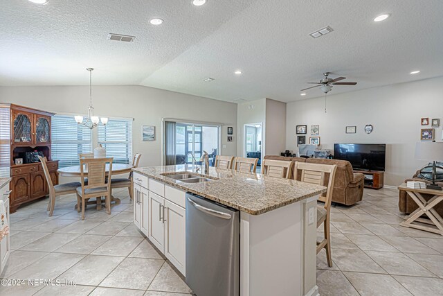 kitchen featuring a center island with sink, sink, hanging light fixtures, vaulted ceiling, and stainless steel dishwasher