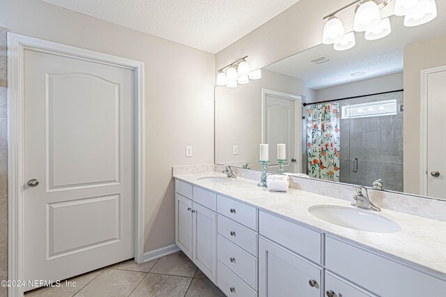 bathroom featuring tile patterned floors, vanity, a textured ceiling, and a shower with shower curtain