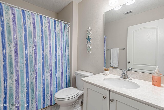 bathroom with vanity, a textured ceiling, and toilet