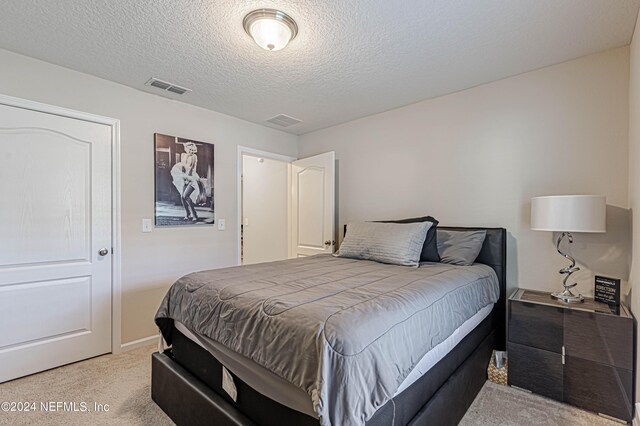 carpeted bedroom featuring a textured ceiling