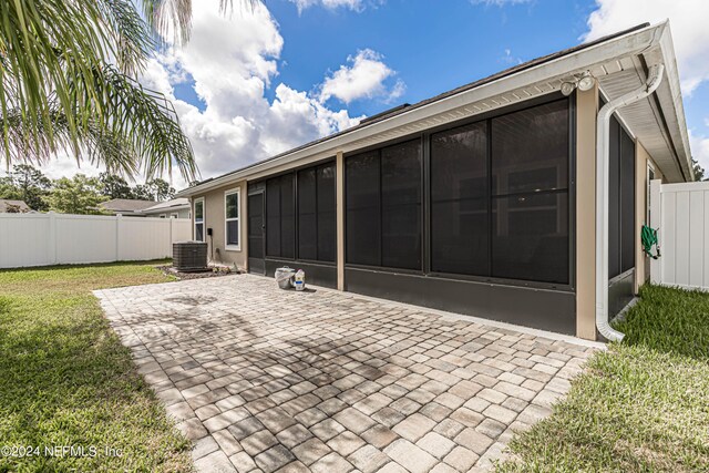 back of house with a patio area, a sunroom, a yard, and central AC unit