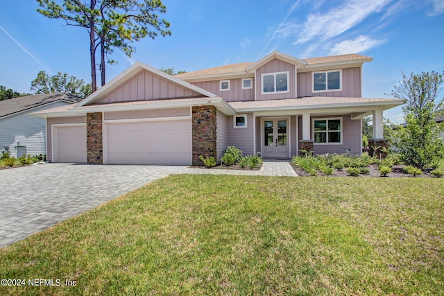 craftsman inspired home with a front yard, french doors, and a garage