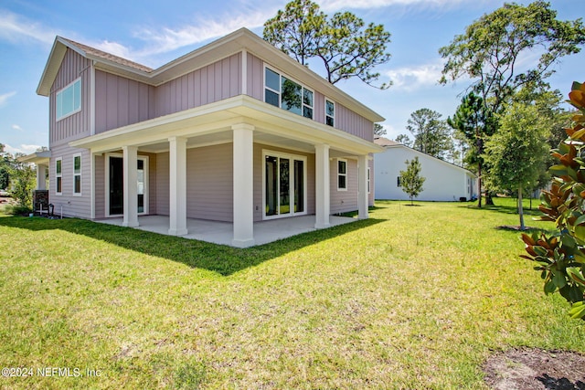 rear view of property with a lawn and a patio