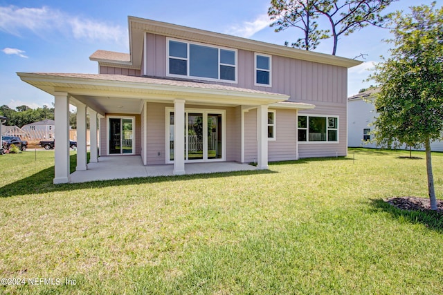 rear view of house with a lawn and a patio area