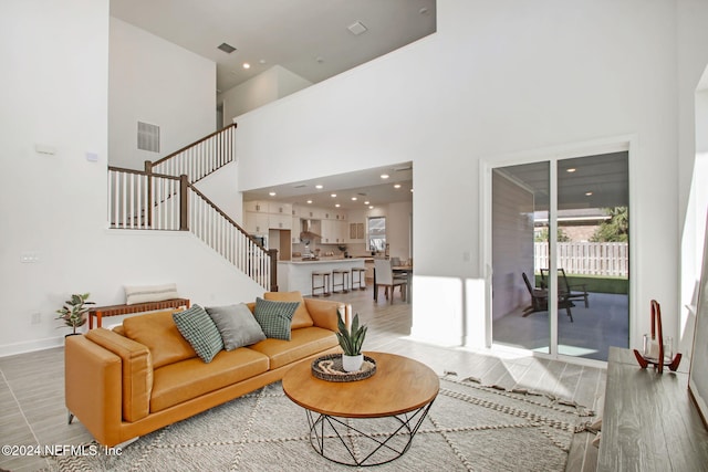 living room featuring wood-type flooring and a high ceiling