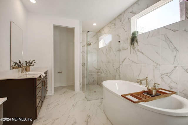 bathroom with vanity, tile walls, and shower with separate bathtub