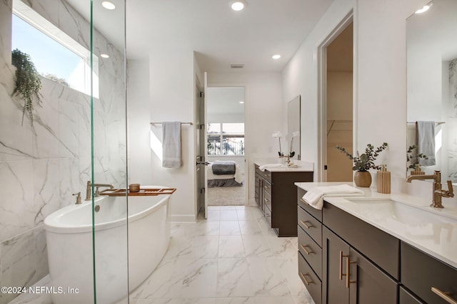 bathroom with a bathing tub, vanity, and tile walls