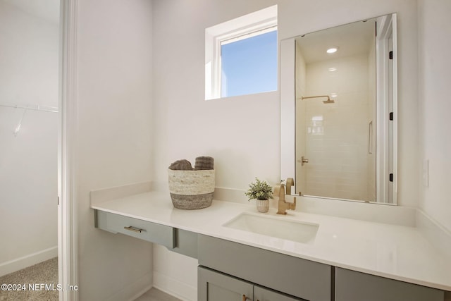 bathroom featuring a tile shower and vanity