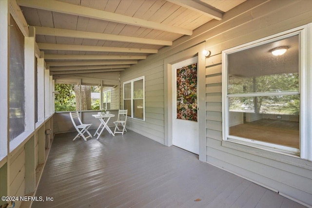 unfurnished sunroom featuring lofted ceiling with beams and wooden ceiling