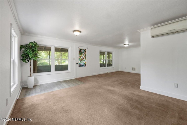 interior space with crown molding, carpet floors, and an AC wall unit